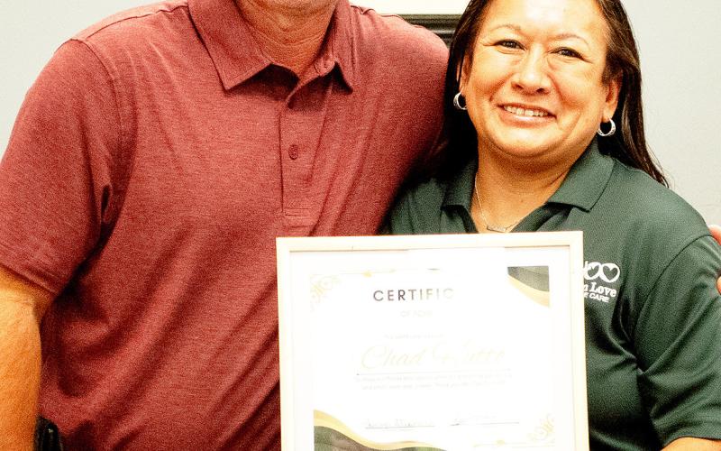 Owner Tina Hutto presents Chad Hutto with a certificate of achievement from Chrisitan Love in recognition of his support of the organization. Zack Clark | Light and Champion