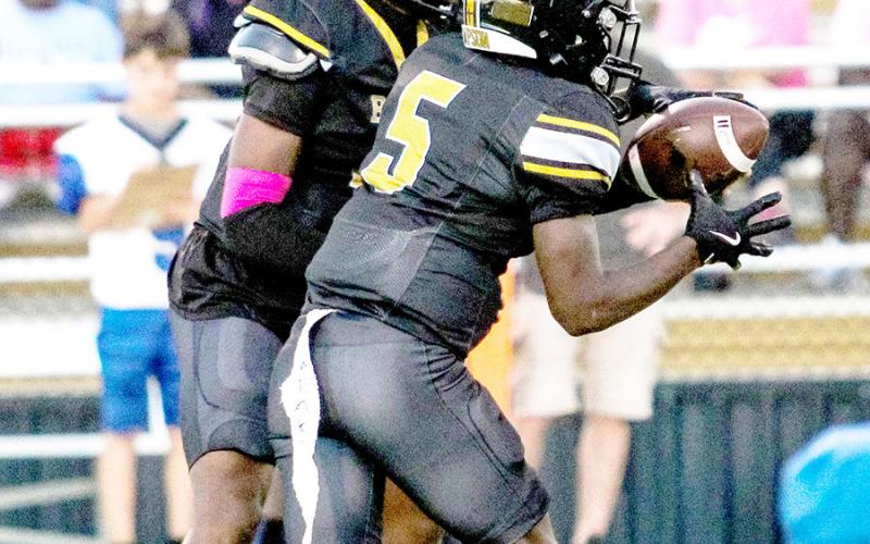 Albert Parker Jr. hands the ball off to Jeffrey Richardson during the Timpson’ game against Hooks Hornets last Friday night. The Bears kept it close but, in the end, fell to the Hornets 3428. TISD Student Media Intern Savannah Cassell |Light and Champion