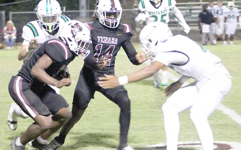Tenaha’s Kori Miles prepares to take on an Overton defender while Christian Chambliss goes in for a block in an effort to spring Miles free. Tenaha Yearbook | Light and Champion