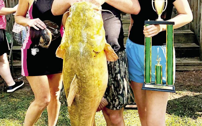 Garrett Marquardt (center)and Briley Hunnicutt (right) teamed up to take the Big Fish trophy and $5,000 prize money for catching a 56.8 pound t athead in the 6th Annual Neches River Life catsh tournament on April 11. (Courtesy Photo)