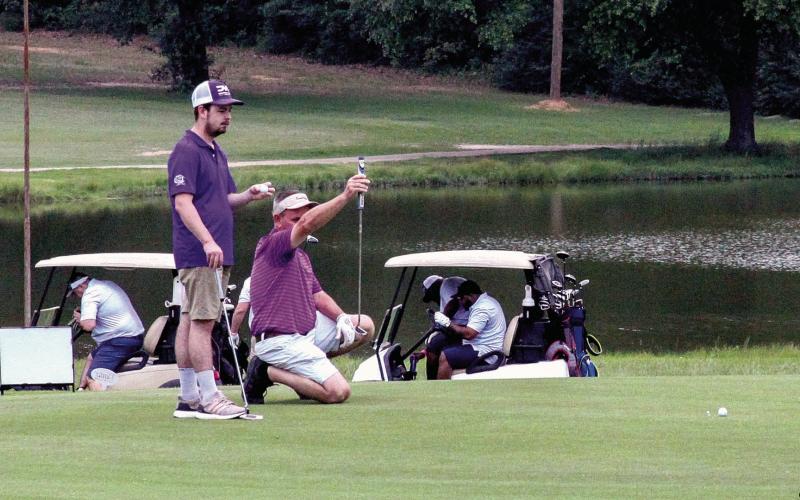 Lining up the putt was one of the record number of players at the third annual Friends of Center Athletic Booster Golf Tournament Fundraiser Saturday. Organizers expected the final figure on the amount raised toward the $500,000 five-year goal this year to be the best yet. (Leon Aldridge photo/The Light and Champion)