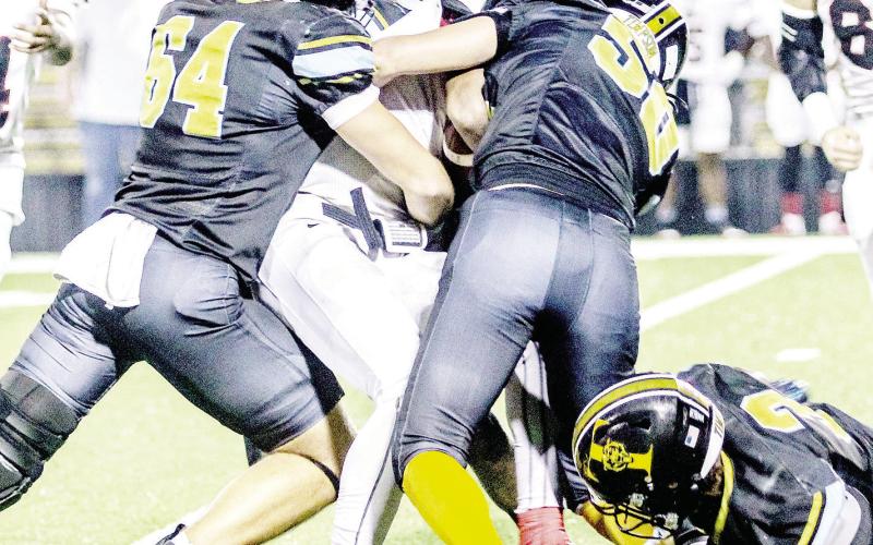 Timpson Bears Mayson Harbison (64), Ja’Haveon Tutt (7), Dillon Wilkie (50) and Braylon Parker (3) gang up to smother a San Augustine Wolves runner in the Bears final game of the season last Friday night. Savannah Cassell | Timpson ISD Student Media Intern