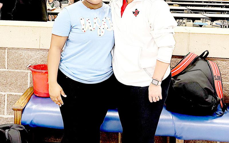 CaLayasia Garrett with her coach Christian Weeks at the Regional girls powerlifting meet held at Emory Rains High School. Dragon Yearbook | Light and Champion