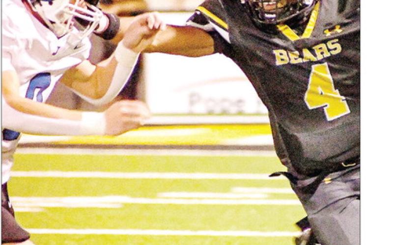 Albert Parker Jr. of the Timpson reaches out to hold off Jadyn Brown of the Joaquin Rams during a run. Timpson ISD | Light and Champion