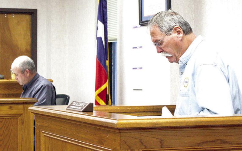 Commissioner Pct. 4 Tom Bellmyer reviews notes at Friday’s commissioners court meeting. The Light and Champion