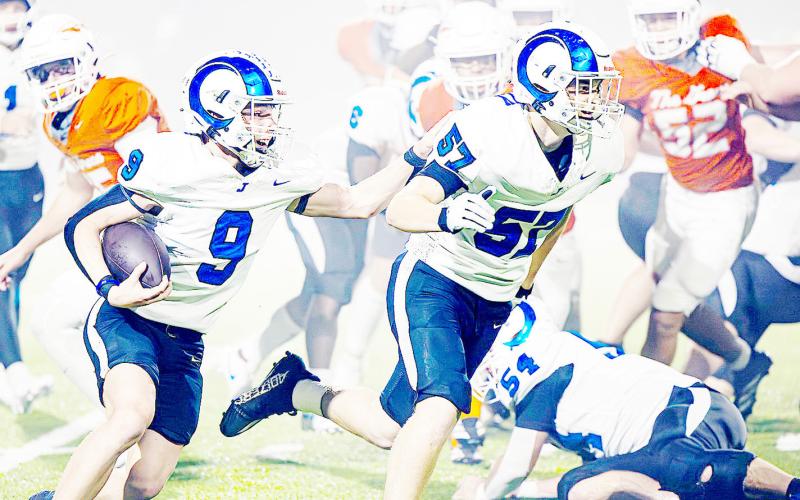 Jadyn Brown (9) lets his teammate know he is right behind him as the duo turn upfield looking to add to the over 500 yards of rushing the Rams put up against the Honey Grove Warriors in Joaquin’s Area Championship win. Lister Publishing | Light and Champion