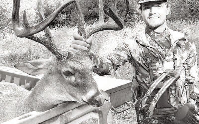 Elkhart archer Luke Johnson, 21, with the 12-point whitetail buck he brought down on his grandfather’s property near Palestine during the Archery Only hunting season. The deer is believed to be 6 1/2 to 7 1/2 years old and unofficially scored at 163 3/8 B&amp;amp;C.
