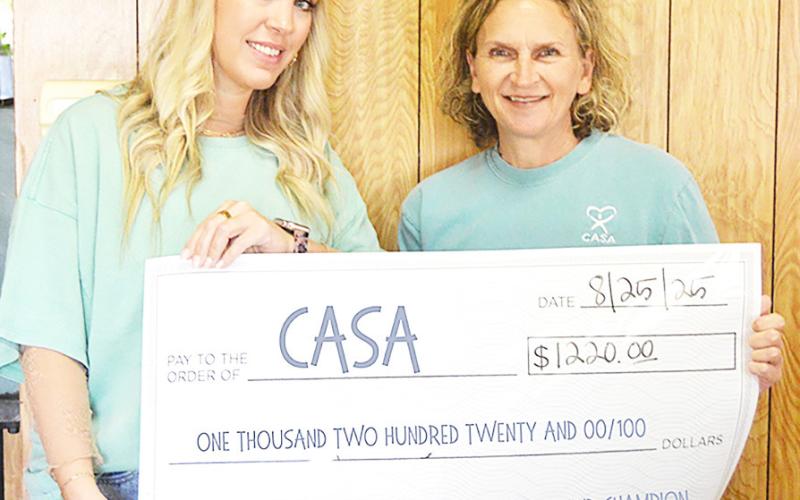 Ashley Chandler, Light and Champion General Manager, (left) presents Tonya Harry of CASA of Nacogdoches and Center with a check for $1,220 raised by funds from a silent auction held at the 2025 Best of Shelby County Banquet. Zack Clark | Light and Champion