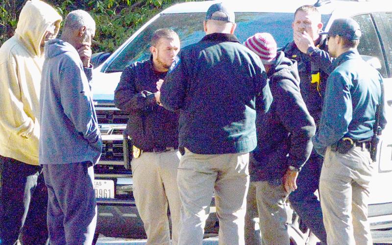 Center police officers interview bystanders at the scene where a Center resident perished in an accidental burning last Friday. Zack Clark | Light and Champion