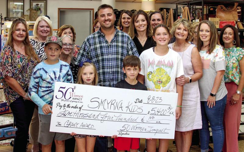 50 Women Impact presents checks to non-profits