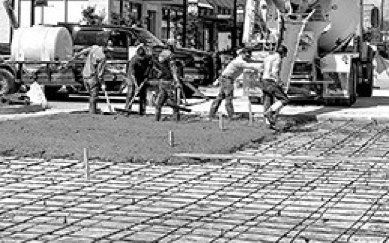 Austin Street reconstruction is closer to completion with the pouring of concrete this week. Frequent rain has hindered progress on replacing asphalt with concrete to correct drainage issues.