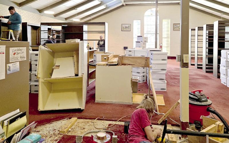 Staff and volunteers move books and disassemble shelving as part of the ongoing renovation project at the Fannie Brown Booth Library. Submitted | Light and Champion