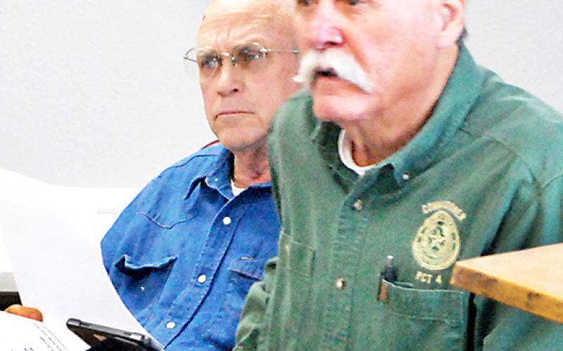 Stevie Smith, Comm. Pct. 3, (left) and Tom Bellmyer, Comm. Pct. 4, listen as Chief Deputy Mike Hanson presents the court with a request concerning outfitting a vehicle for the sheriff’s department. MaggieVaughn | Light and Champion