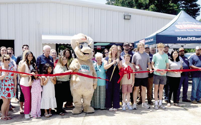 Owner Emily May cuts the ribbon to mark the grand opening of M&amp;amp;M Roofing at its location in Center. Zack Clark | Light and Champion