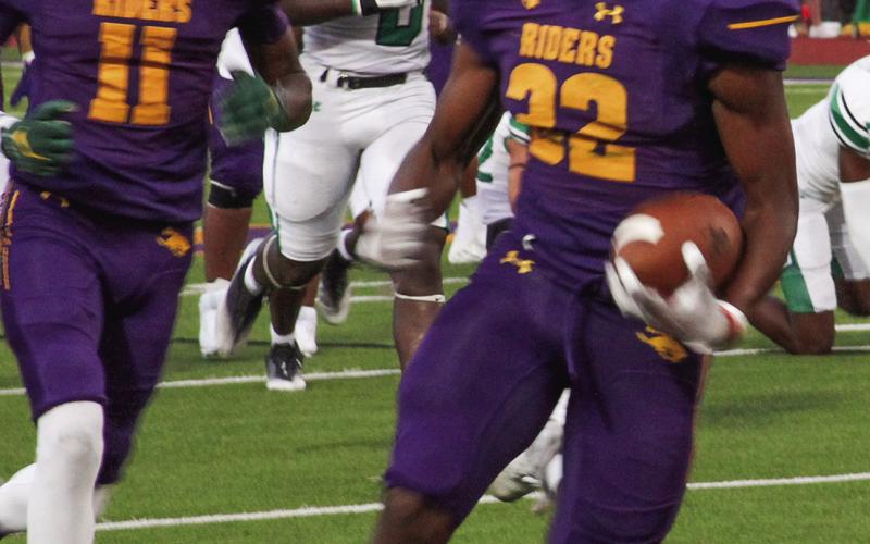 q Kaden Dixon (32) looks for running room with Jeremiah Ratcliff (11) covering his back. (Leon Aldridge photo – The Light and Champion)