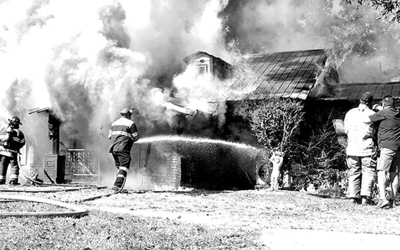 The Cartwright home was engulfed in flames as the Center and Timpson fire departments attempt to keep the blaze at bay. Dennis Phillips | The Light and Champion