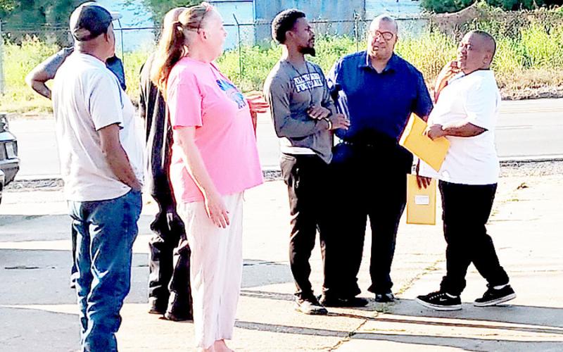 Tenaha mayor O’Neal Jones (second from right) and other members of the city council and members of the public present at the Aug. 25 city council meeting talk outside the city hall building after another contentious city council meeting. David Danley | Light and Champion