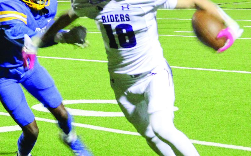 t Lance Wilburn eludes a tackler and looks for the end zone. He found paydirt at the end of this run adding six points to the scoreboard. (Leon Aldridge photo / The Light and Champion)