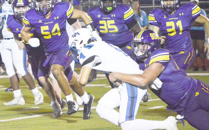 A Center defender takes down a Spring Hill runner while a purple wall of Roughriders Eli Lout, Jace Radney, Jaylan Henderson and Jose Marquez bears down to assist. David Danley | Light and Champion