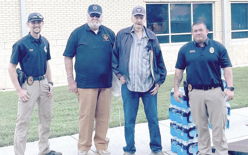 Members of Masonic Lodge Sam Samford #149, Allan Ricketson and Arnold Sammy, donate water to Center P.D. and Shelby County Sheriffâ€™s Office. Accepting the donation are officers Jerry Payne (left) and John Clevenger (right). Zack Clark | Light and Champion