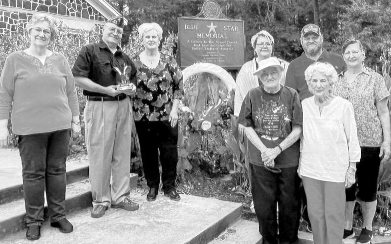 The Center Garden Club celebrated Veterans Day by placing a wreath by the Blue Star Memorial Plaque located at the Community House in Center. This is an annual event honoring Shelby County veterans. Attending were (left to right) Robbie Kerr, Kevin Gratehouse (Marine) holding a golden eagle award presented by the club; Carole Ann Chance, Marsha and Billy Barrett, Pam Sykes, Janette Wittman and Maelinda Swanzy. Photo submitted by the Center Garden Club