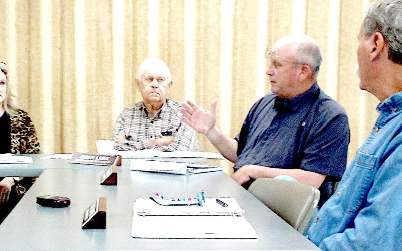 County Judge Allison Harbison (far left) and commissioners Jimmy Lout (left) and Stevie Smith (right) listen to Comm. Stevie Smith outline water drainage issues.