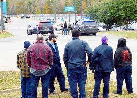 Walmart employees gather across the street from the store after being evacuated from the building after a bomb threat was received Thursday morning, Dec. 18. David Danley | Light and Champion