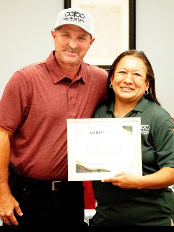 Owner Tina Hutto presents Chad Hutto with a certificate of achievement from Chrisitan Love in recognition of his support of the organization. Zack Clark | Light and Champion