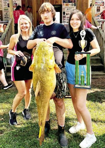Garrett Marquardt (center)and Briley Hunnicutt (right) teamed up to take the Big Fish trophy and $5,000 prize money for catching a 56.8 pound t athead in the 6th Annual Neches River Life catsh tournament on April 11. (Courtesy Photo)