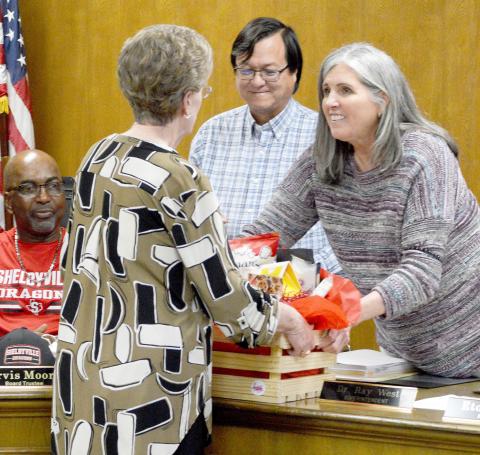 Esther Harrison (middle) is presented a gift basket by Shelbyville ISD Board of Trustees president Etola Jones in honor of Harrison receiving a state UIL Sponsor Excellence award for her many years of service to Shelbyville ISD and other area schools, while board member Arvis Moore and Superintendent Dr. Ray West look on. David Danley | Light and Champion