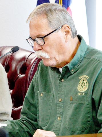 Comm. Pct. 4 Tom Bellmyer reviews bids submitted for road materials at the Sept. 17 commissioners’ court meeting. Zack Clark | Light and Champion