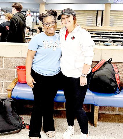 CaLayasia Garrett with her coach Christian Weeks at the Regional girls powerlifting meet held at Emory Rains High School. Dragon Yearbook | Light and Champion
