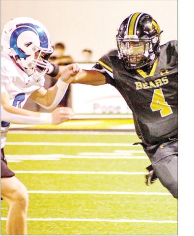 Albert Parker Jr. of the Timpson reaches out to hold off Jadyn Brown of the Joaquin Rams during a run. Timpson ISD | Light and Champion