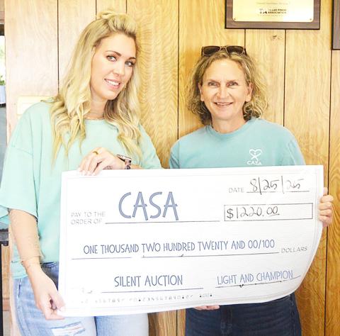 Ashley Chandler, Light and Champion General Manager, (left) presents Tonya Harry of CASA of Nacogdoches and Center with a check for $1,220 raised by funds from a silent auction held at the 2025 Best of Shelby County Banquet. Zack Clark | Light and Champion