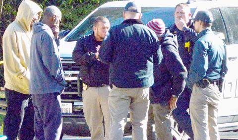Center police officers interview bystanders at the scene where a Center resident perished in an accidental burning last Friday. Zack Clark | Light and Champion