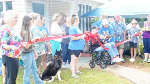 Dr. Robert Hughes cuts the ribbon for the open house held last Saturday for Happy Tails Adoption Center. Hughes donated his former veterinary practice building to the agency to give it a home. Zack Clark | Light and Champion