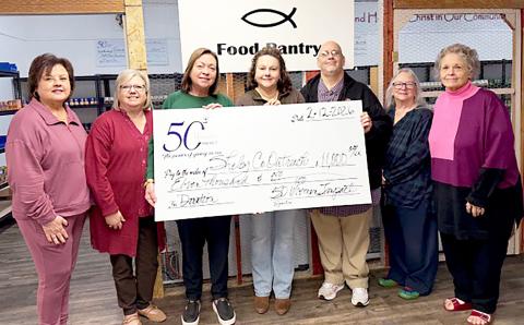 Members of 50 Women of Impact present staff members of Shelby County Outreach Ministries with a check for $11,000 to help fund the organization’s many assistance programs. Submitted | Light and Champion