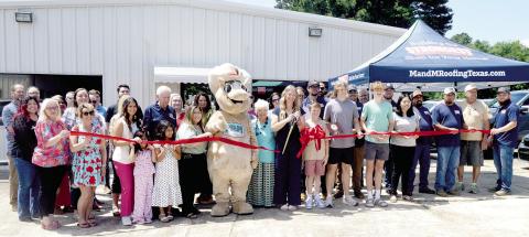 Owner Emily May cuts the ribbon to mark the grand opening of M&amp;M Roofing at its location in Center. Zack Clark | Light and Champion